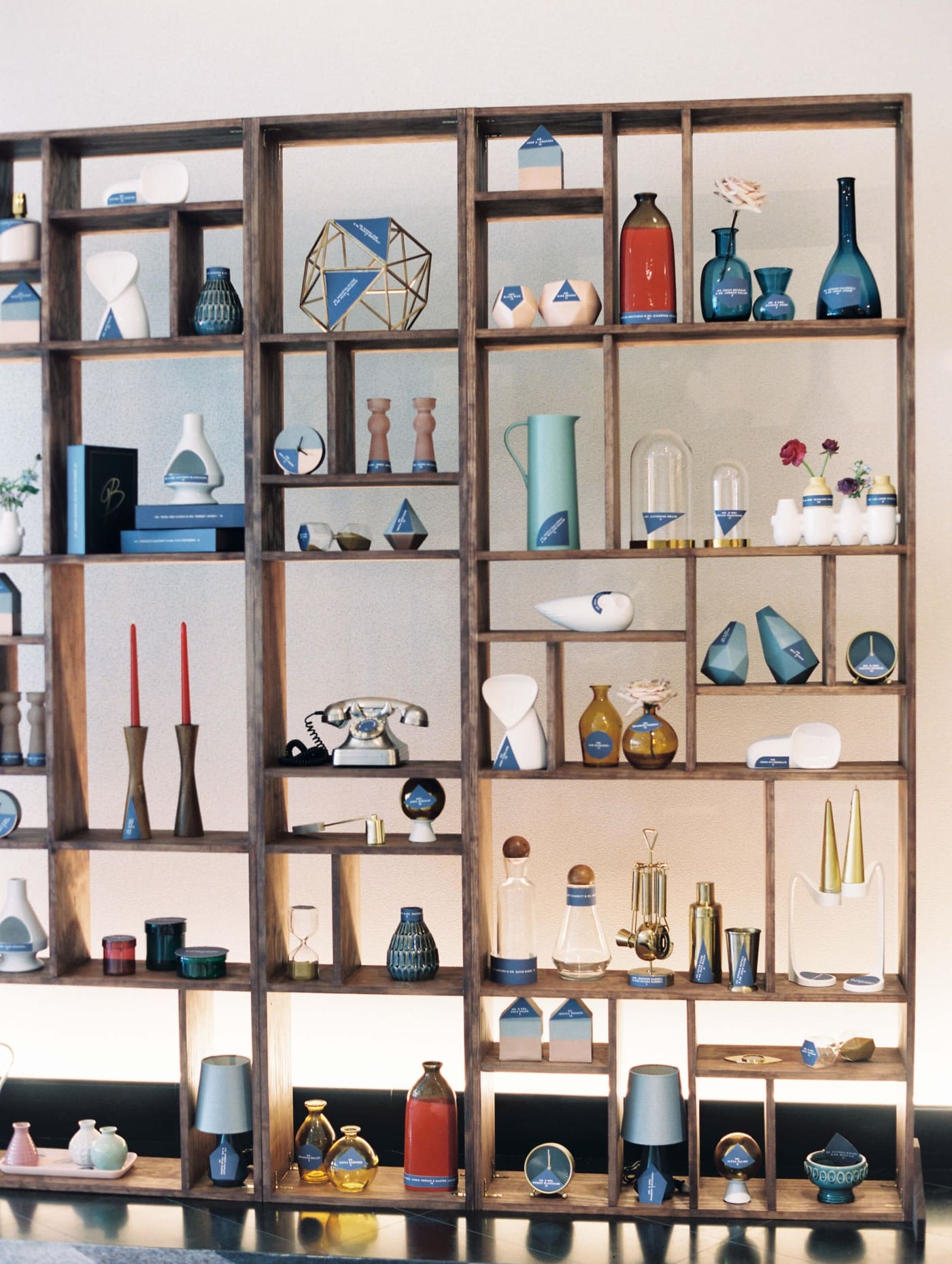 A custom-built shelf with mid-century modern decor serving as a wedding seating chart