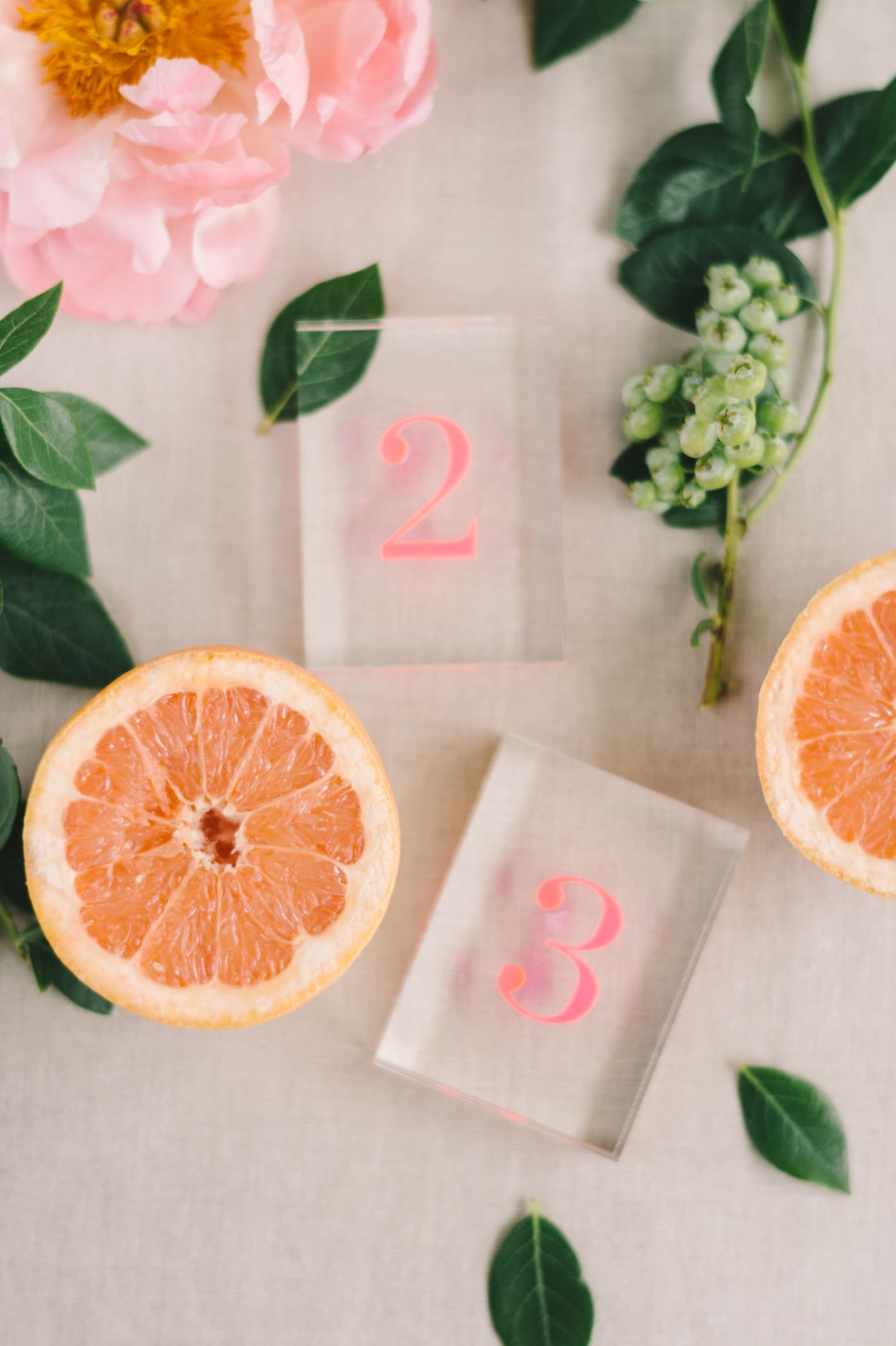 Custom acrylic table numbers surrounded by citrus fruits
