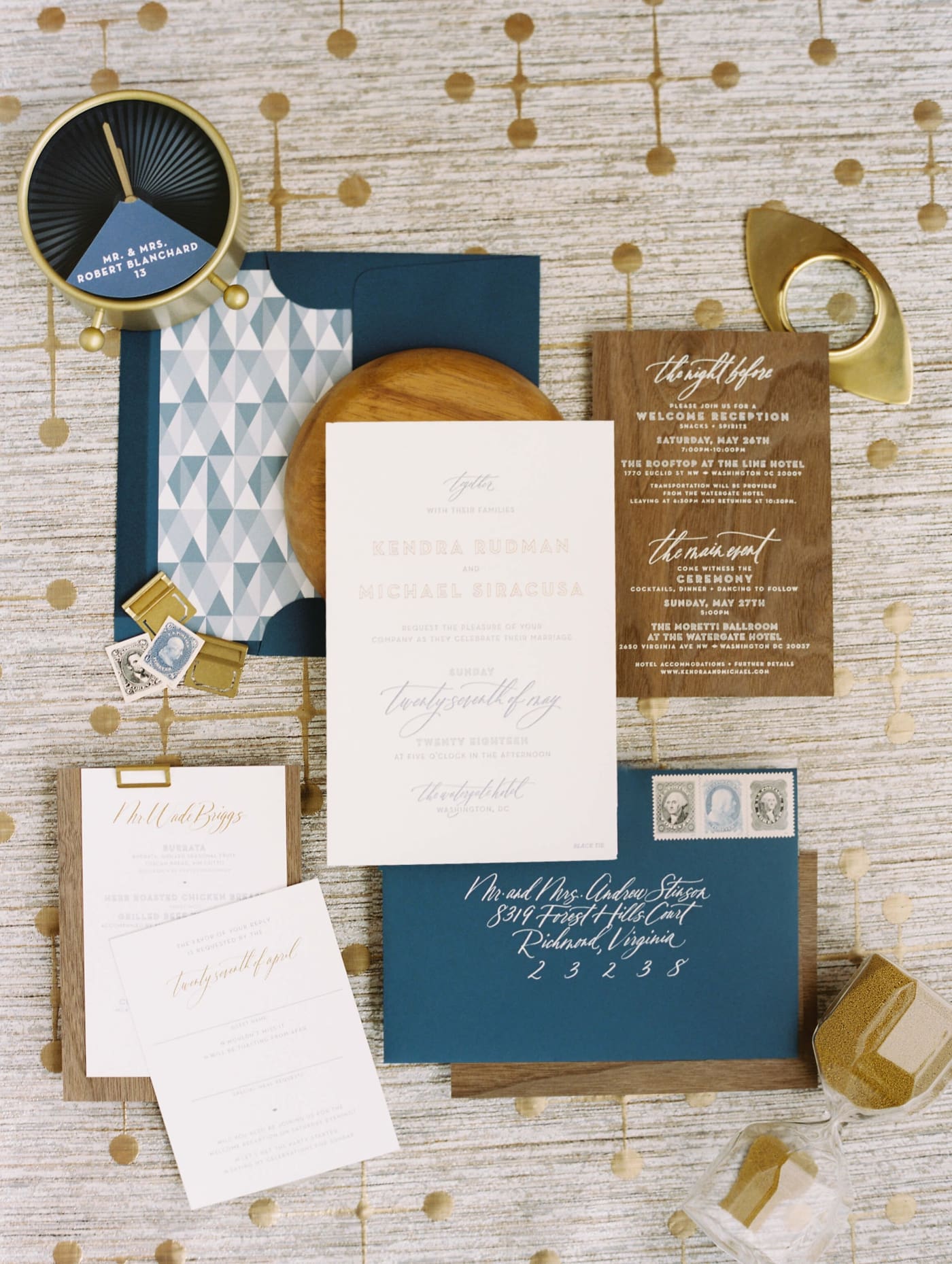 A flat lay of a blue and gold wedding invitation suite for a mid-century modern wedding